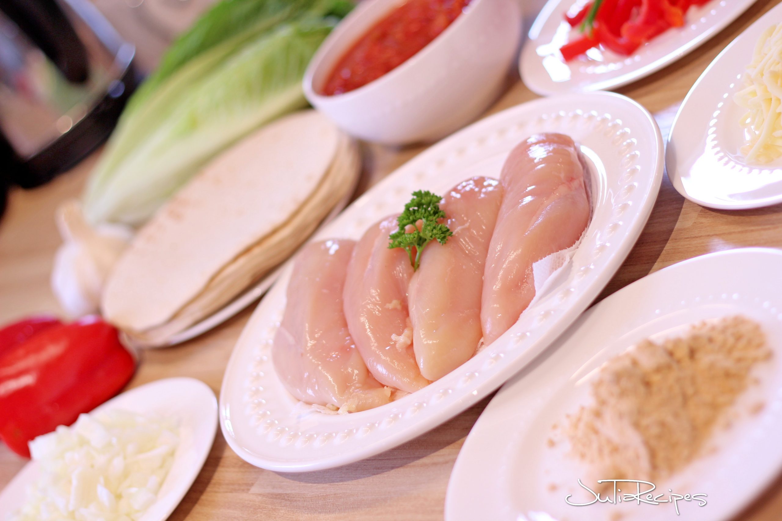 Chicken breasts as ingredient for mexican fajitas with tortillas and salsa.
