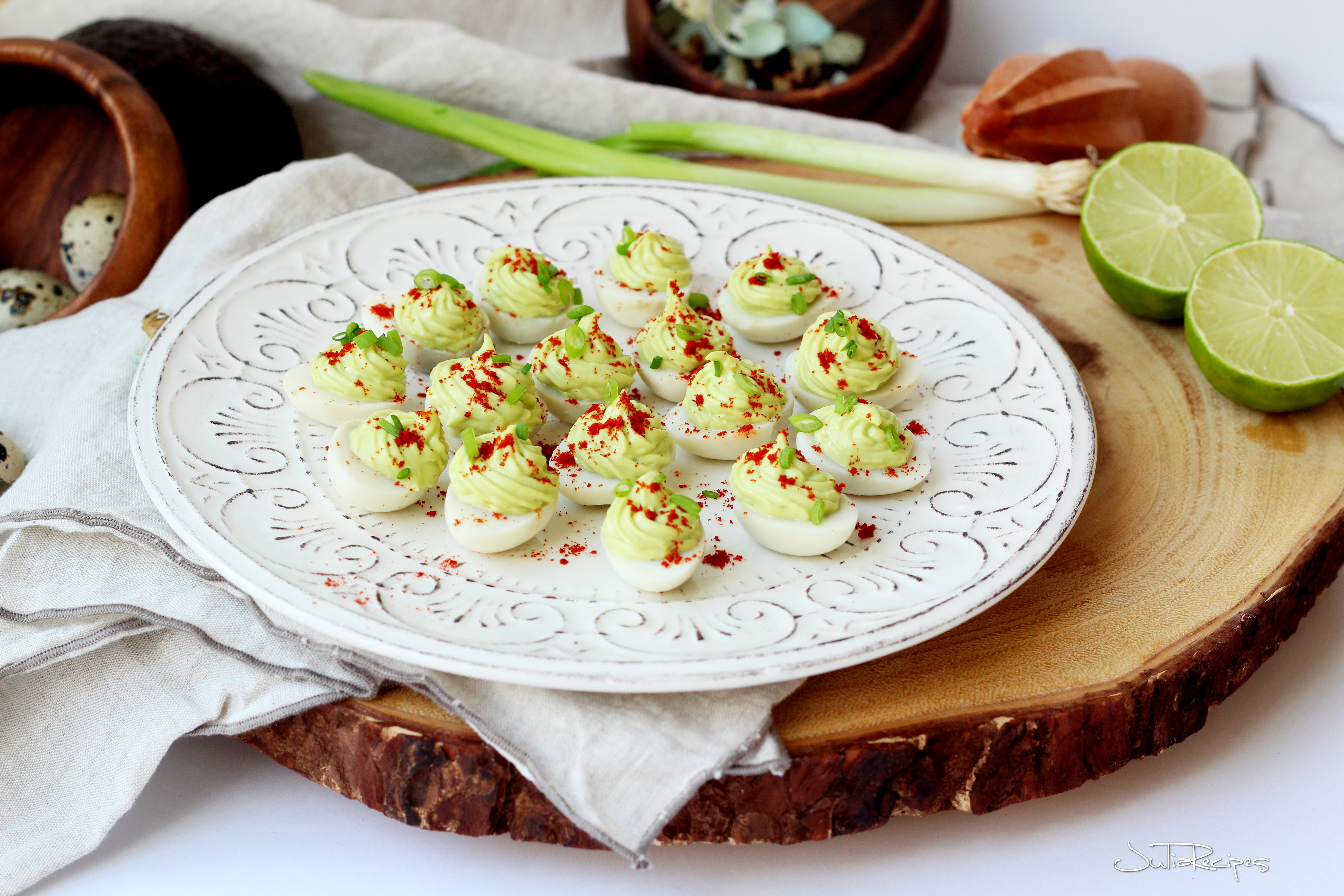 avocado deviled quail eggs on white plate with decoration