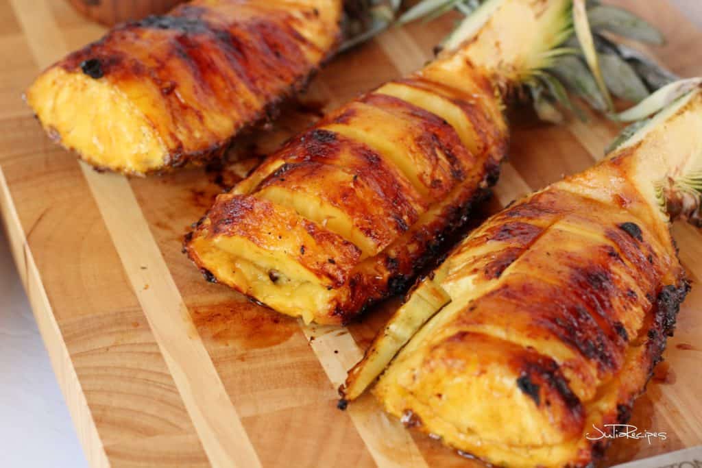 Grilled pineapple cut in wedges on wooden board