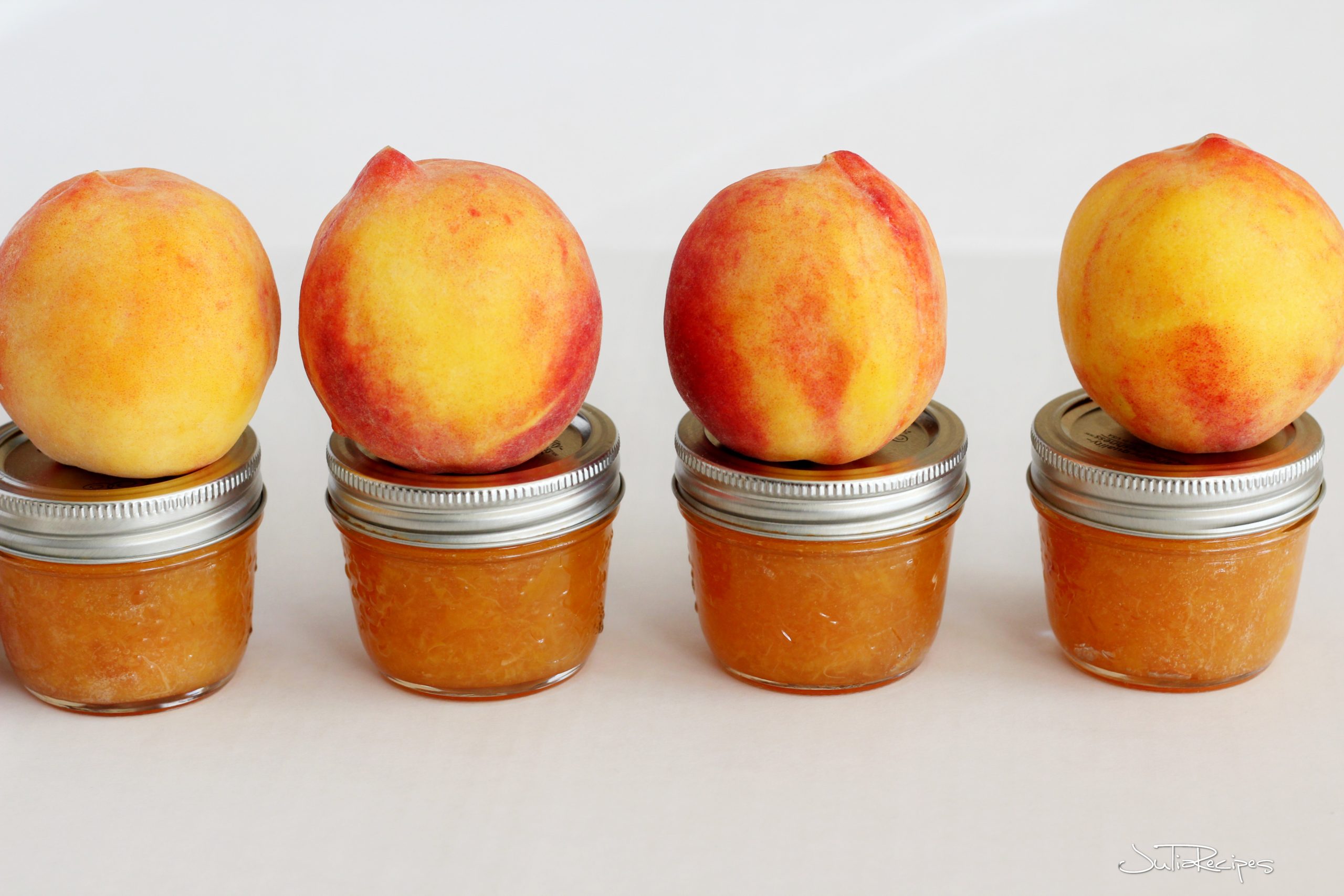 peaches on top of peach jam jars