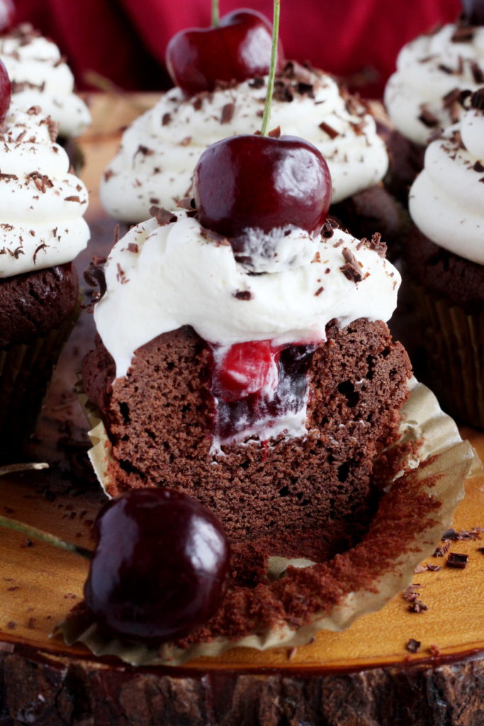 black forest cupcake cut in half with cherry on top
