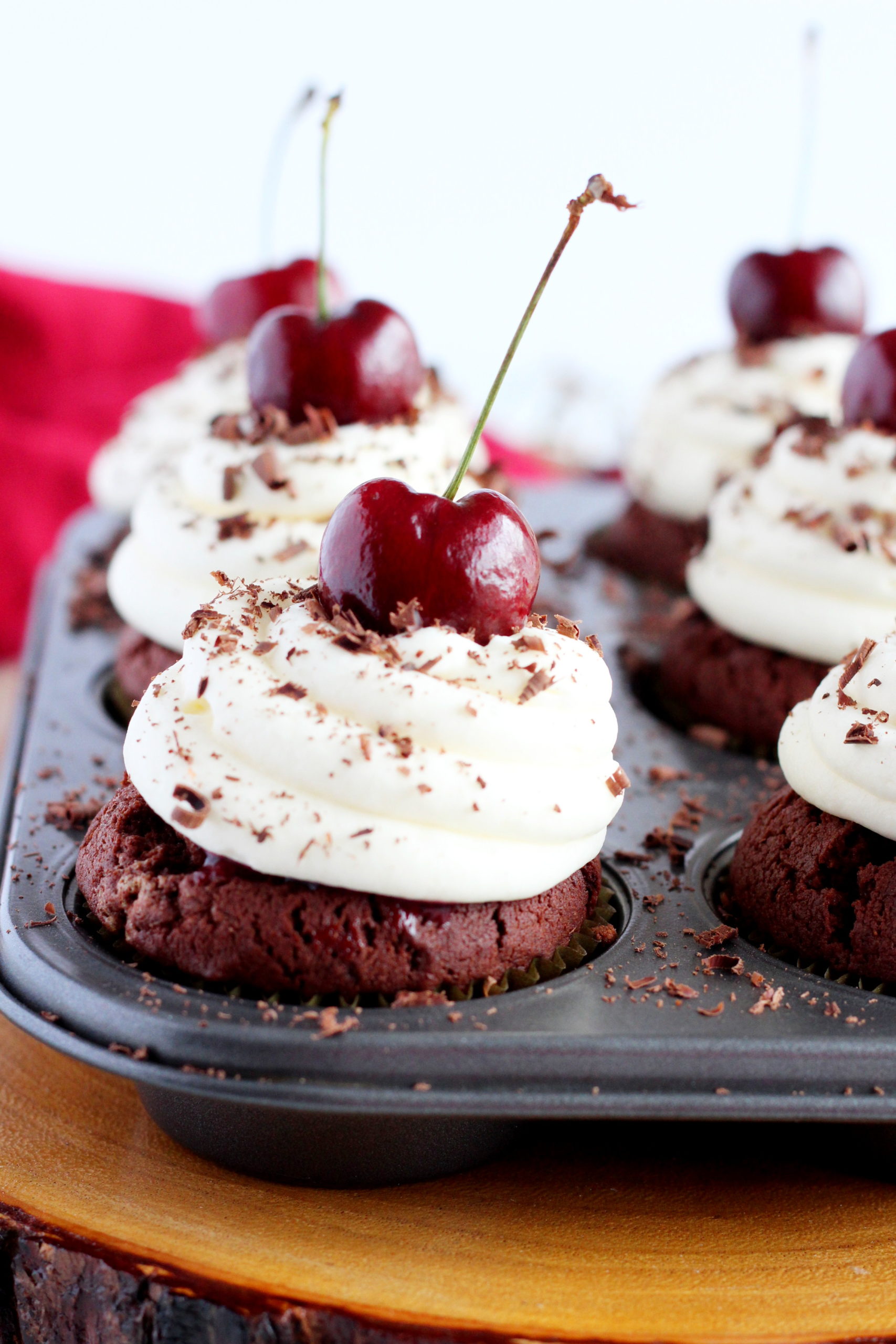 close up of chocolate cupcakes with cherries
