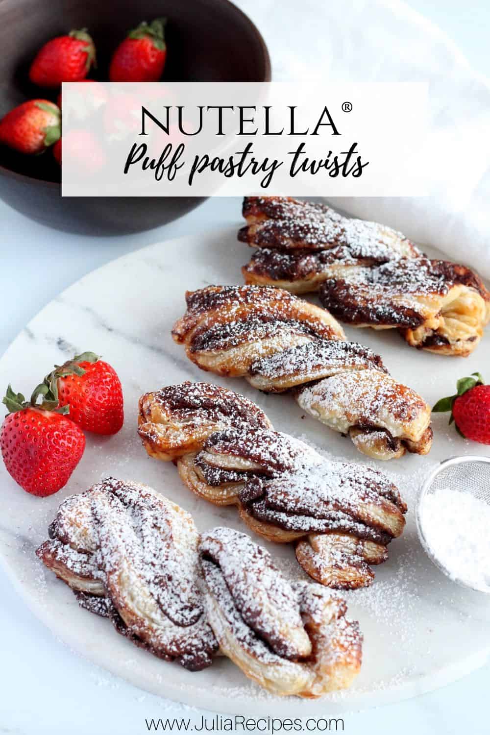 Puff pastry Nutella twists with strawberries in the background and powdered sugar wand.