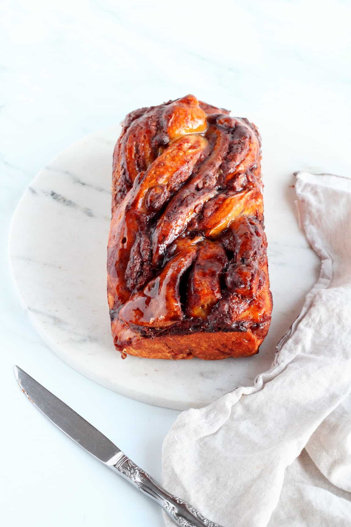 loaf of chocolate babka with almond filling on marble tray