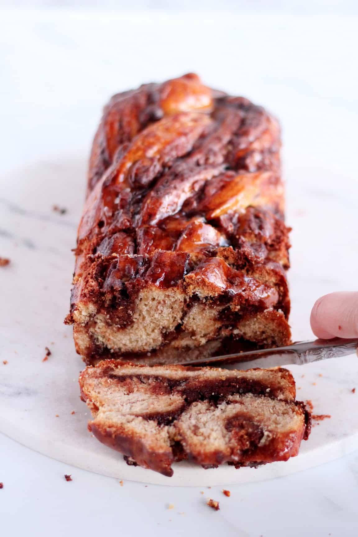 chocolate babka with almond filling first slice cutting on white table