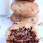 thick chocolate chip cookies cut in half with chocolate dripping down