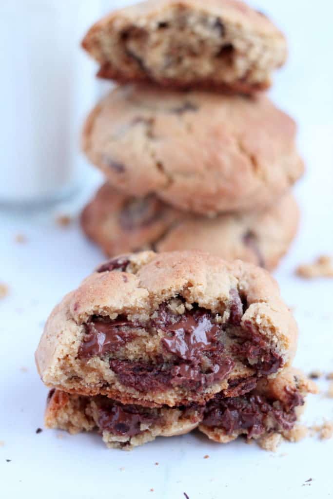 thick chocolate chip cookies cut in half with chocolate dripping down