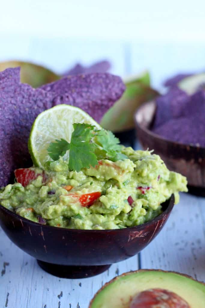 Guacamole dip in wooden bowl with corn chips