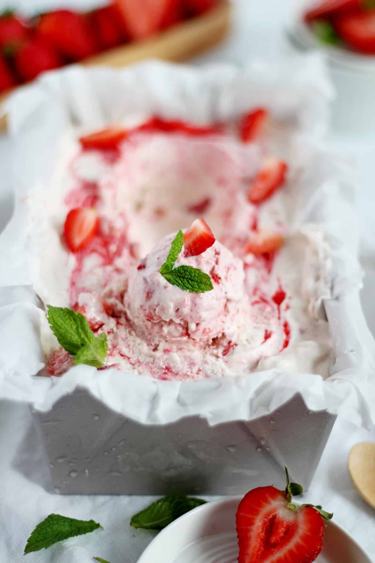 strawberry ice cream in loaf pan decorated with mint leaves