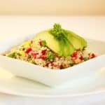 quinoa salad in white bowl topped with avocado