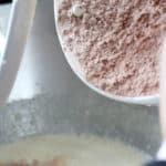 adding flour and cocoa powder into liquid ingredients