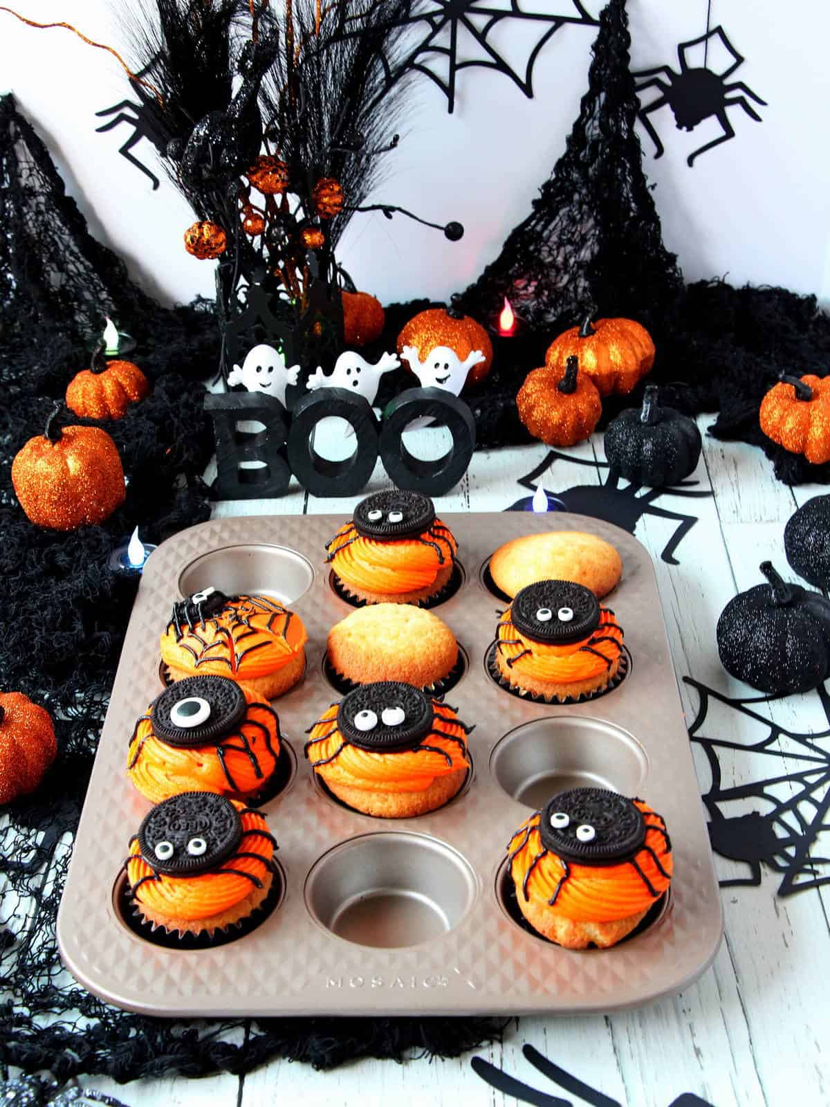 vanilla cupcakes with orange frosting and oreo spiders on Mosaic muffin pan