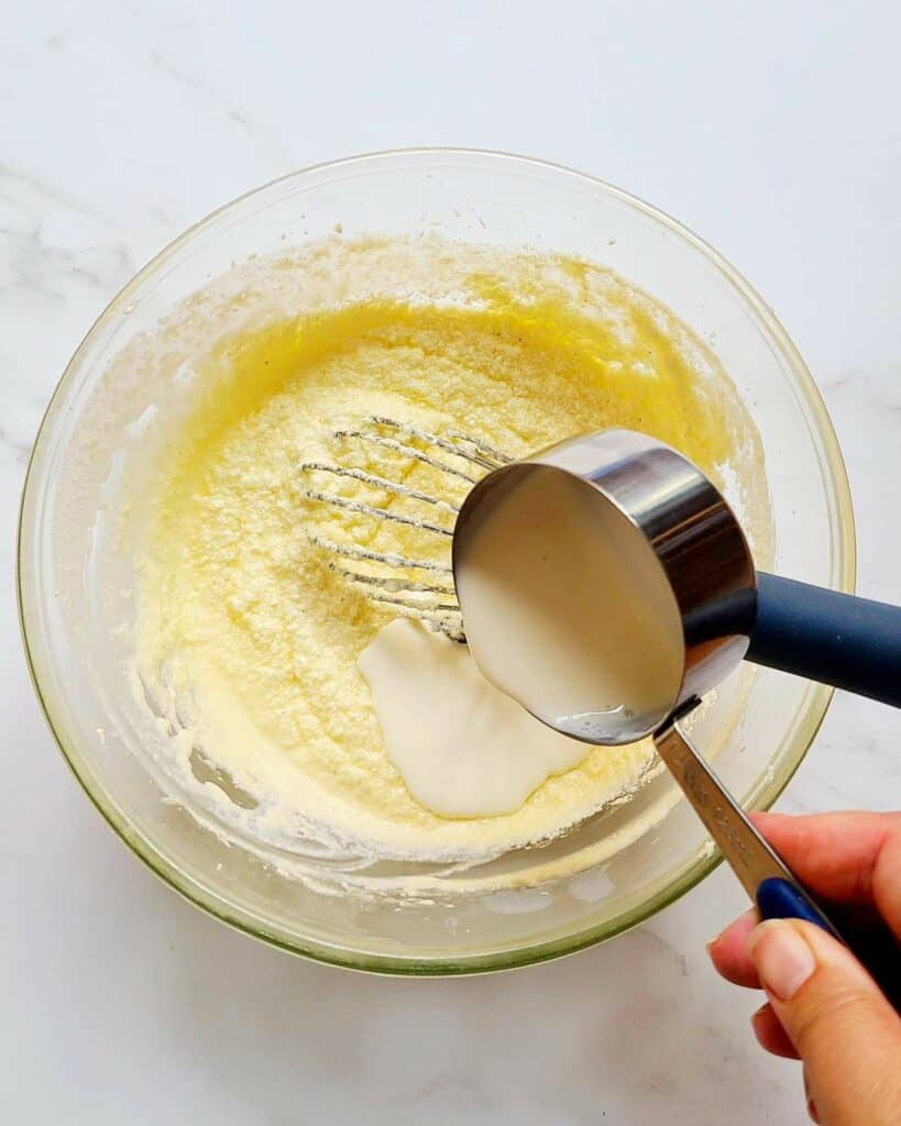 Adding heavy cream to creamed butter.
