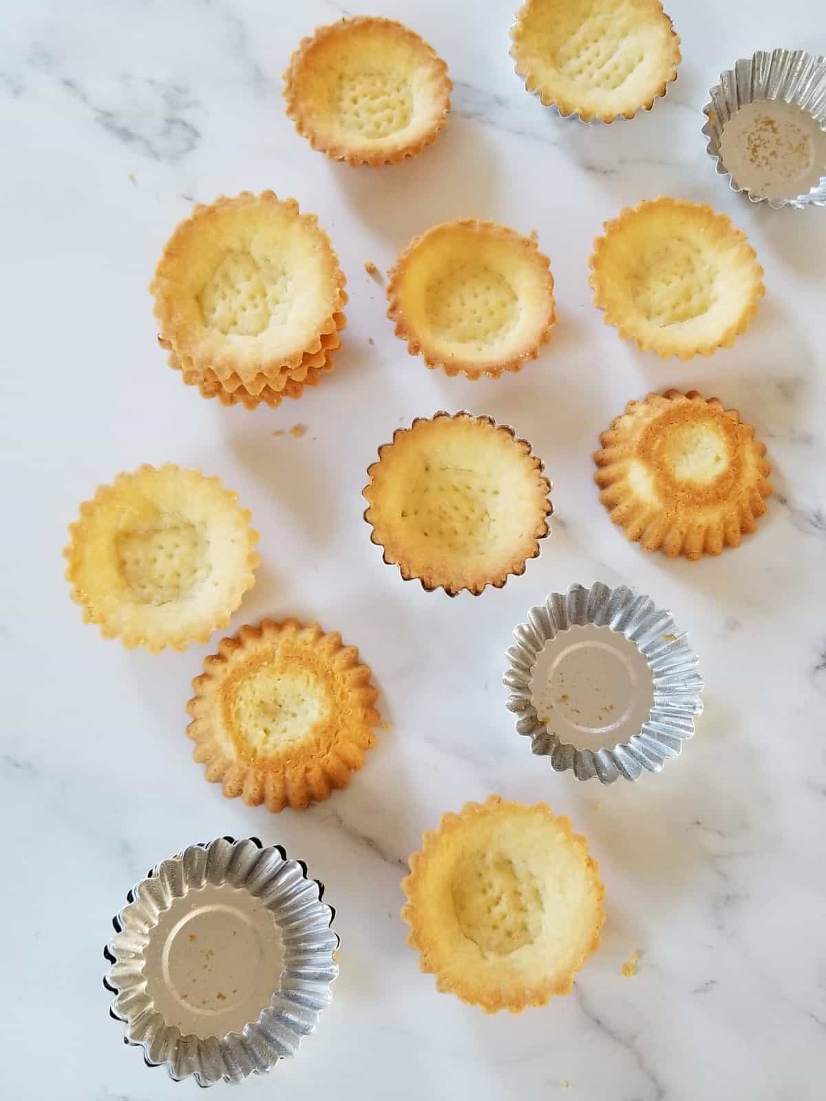 mini tarts baked in individual moulds, scattered on marble background