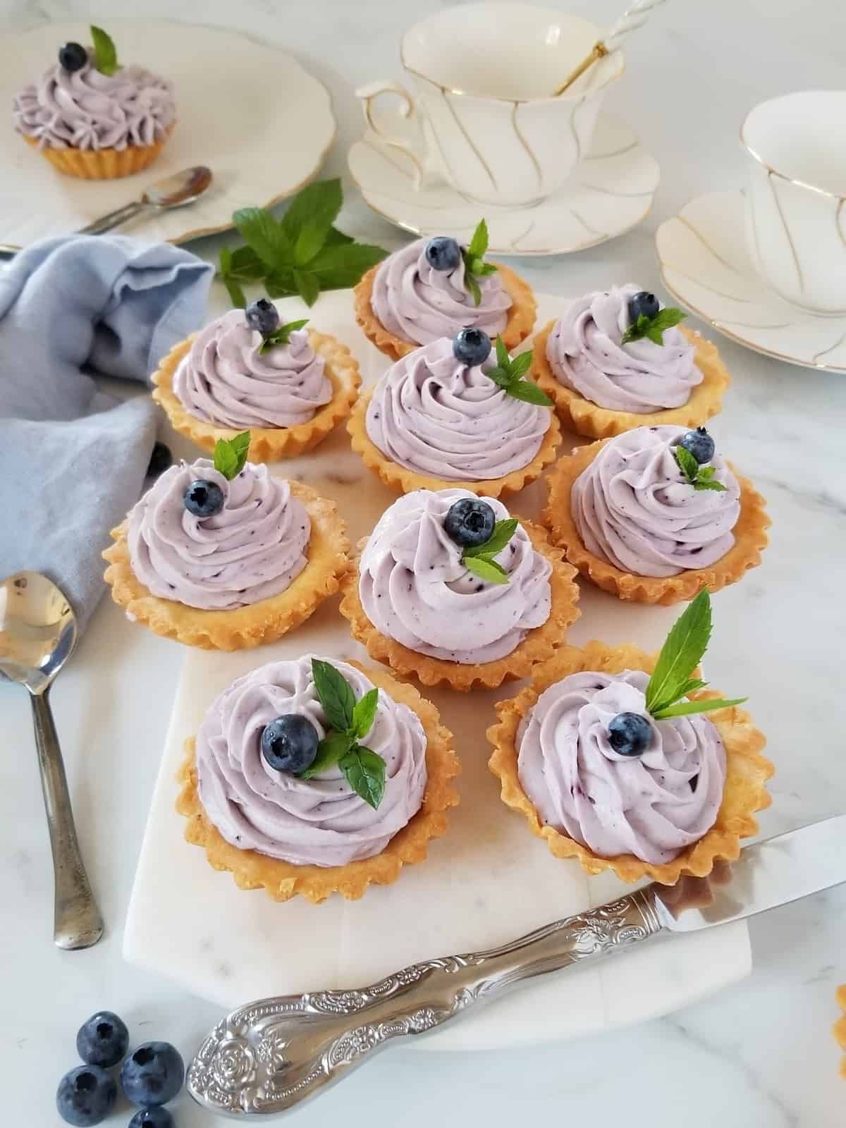mini tarts filled with blueberry mascarpone cream, decorated with fresh blueberries and mint leaves