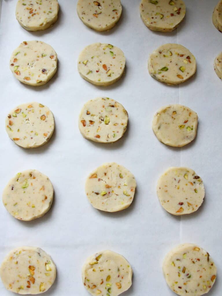 pistachio cookie dough cut out circles, placed on baking sheet