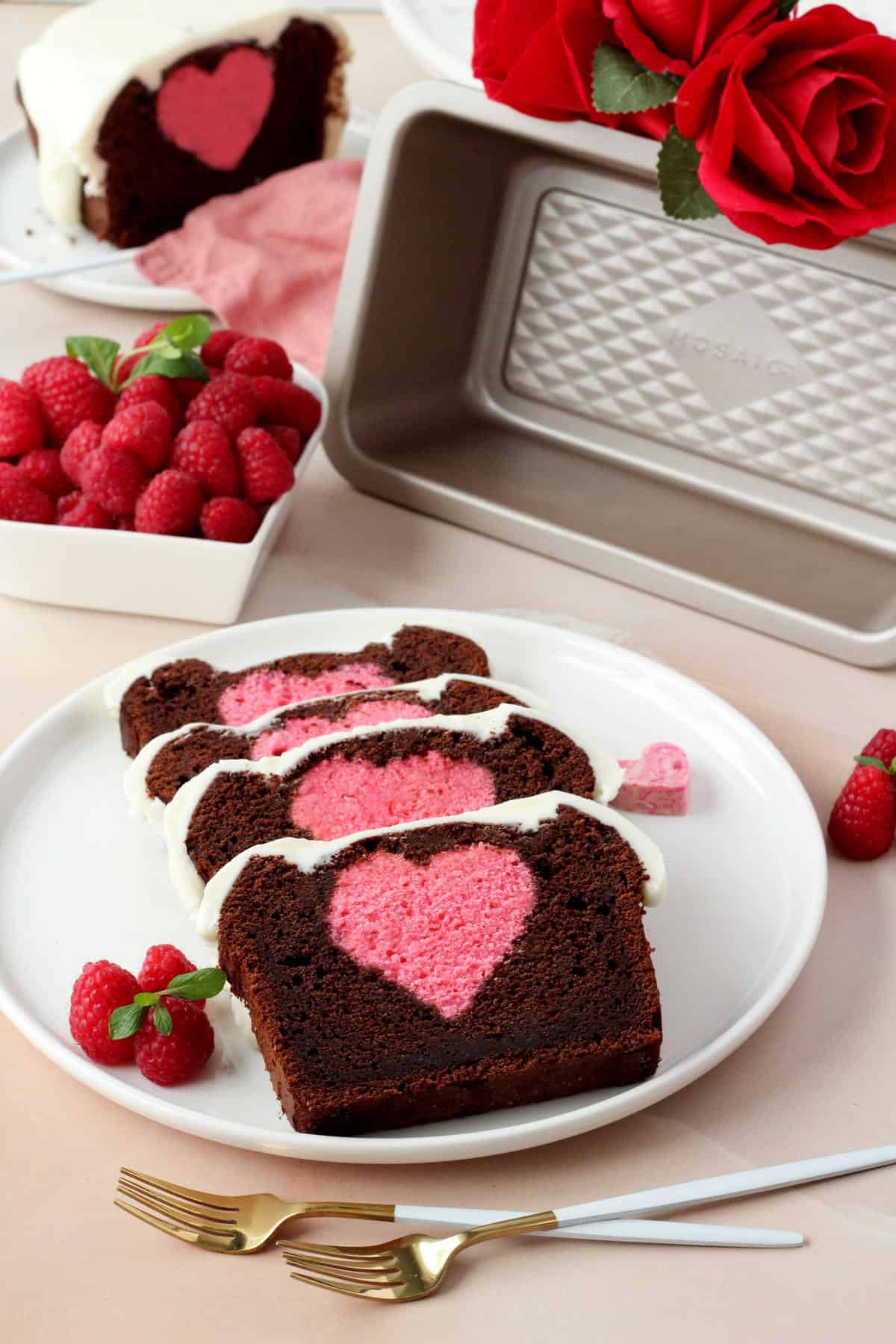 chocolate pound cake with heart inside sliced on white plate with pink background