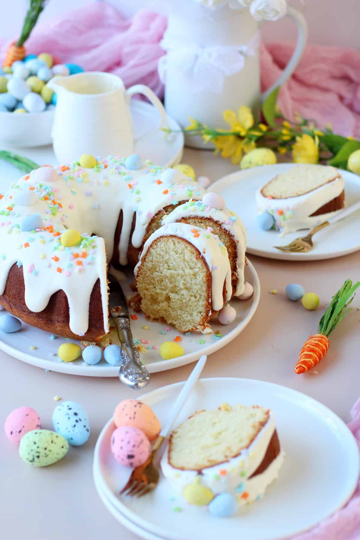 Easter bundt cake with cream cheese glaze, on a white plate. Easter decoration all around