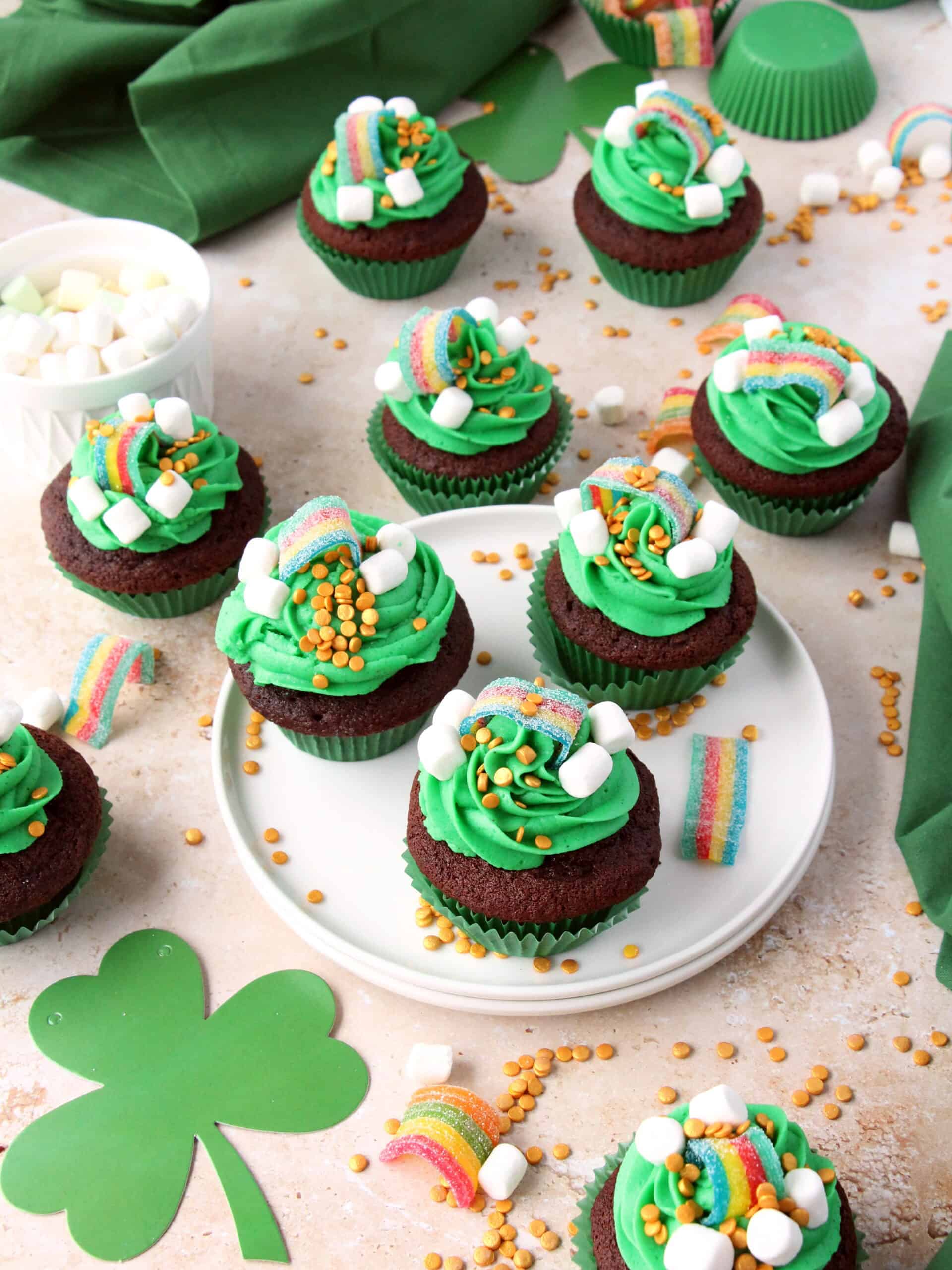 st patrick's day cupcakes on white plate. Golden sugar candies around with rainbow candies.